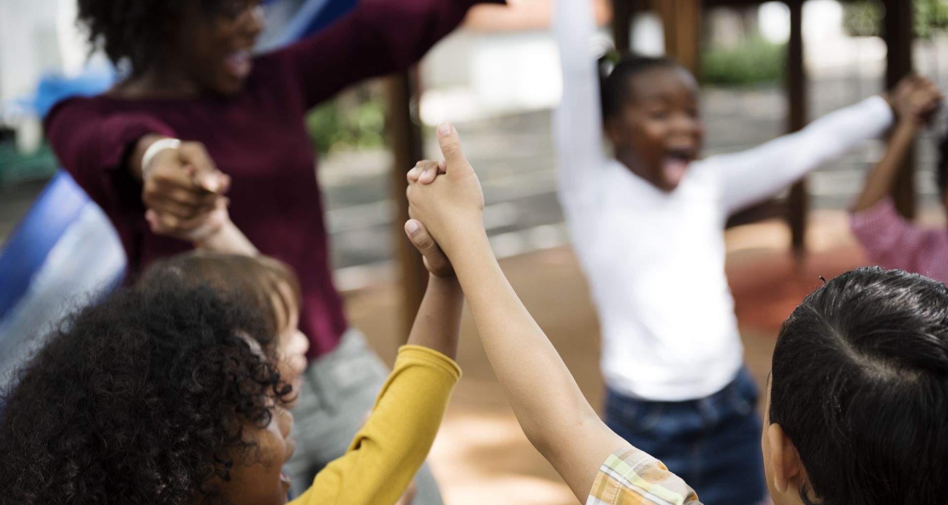 Group of diverse kindergarten students hands up together